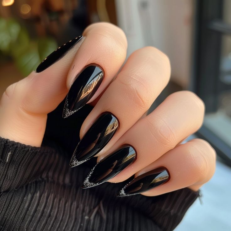 Elegant Black Almond-Shaped Nails with Glossy Finish and Silver Detailing.