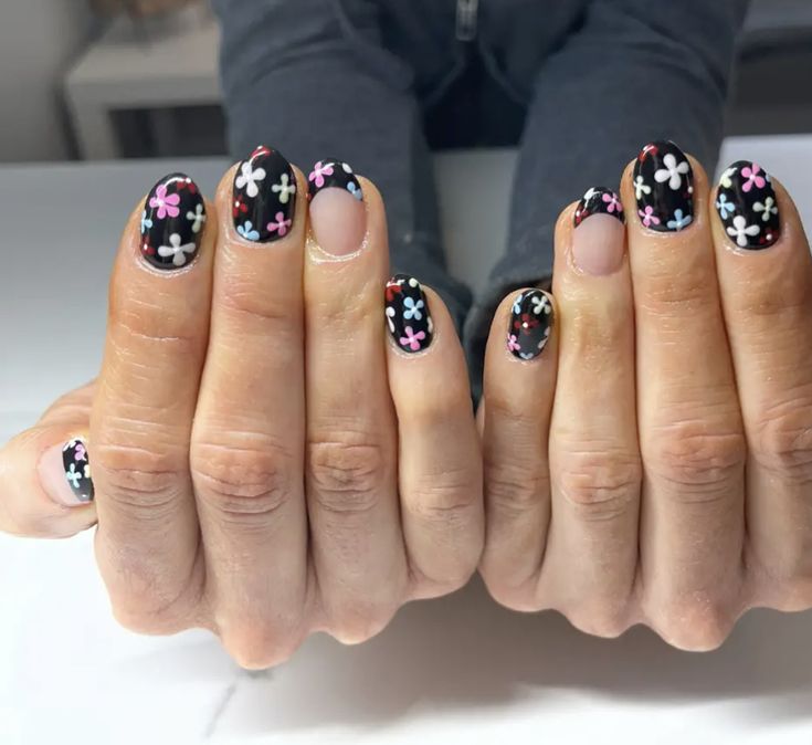 Vibrant Floral Nail Design on Sleek Black Background with Rounded Shape.