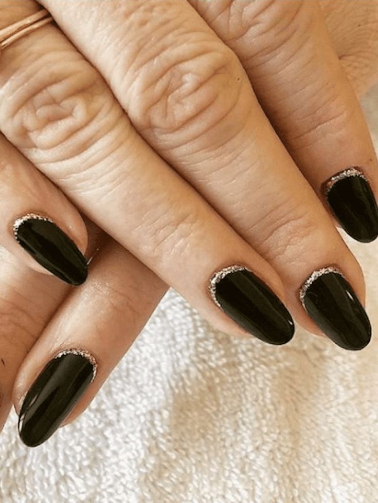 Sophisticated Black Nail Design with Glossy Finish and Silver Glitter Accents