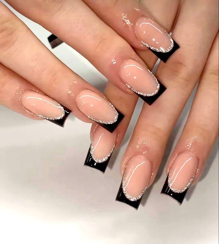 Chic Nail Design: Nude Polish with Black Tips and Glamorous Silver Glitter Accents.