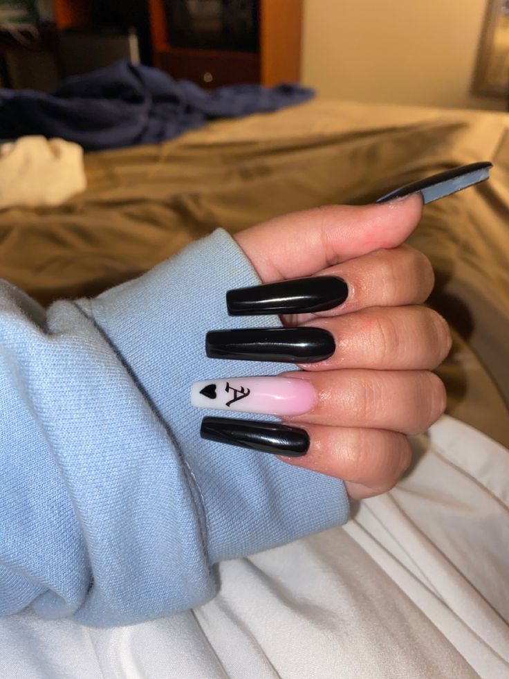 Striking Black Nail Art with Playful Accent Heart on Pastel Background.