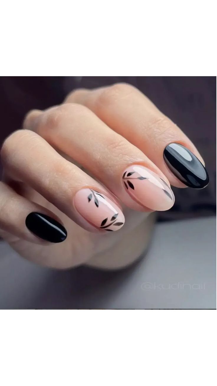 Elegant Matte Black and Soft Nude Nail Design with Delicate Leaf Patterns.