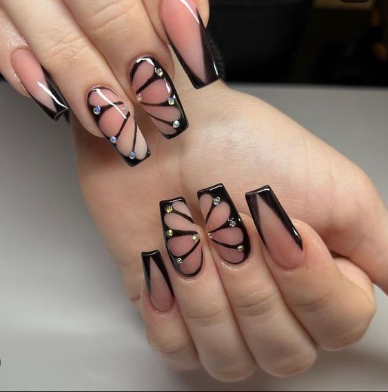 Sophisticated Nude and Black Nail Design with Geometric Patterns and Sparkling Embellishments.