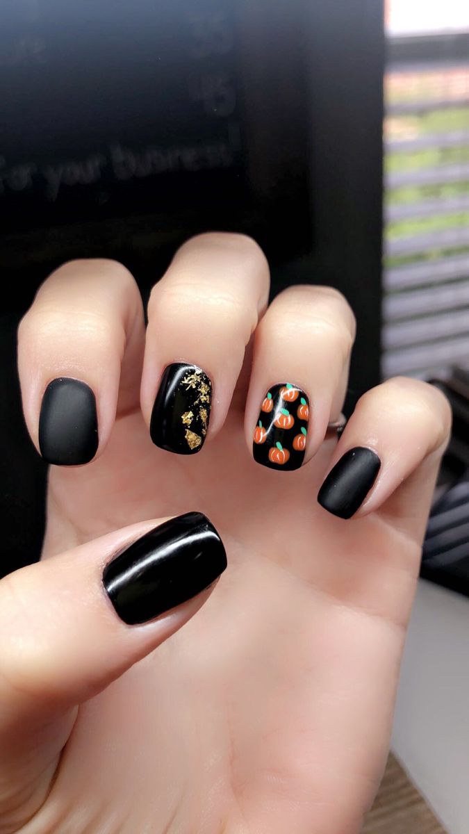 Chic Matte Black Nail Art with Pumpkin Accents and Luxurious Gold Foil Details