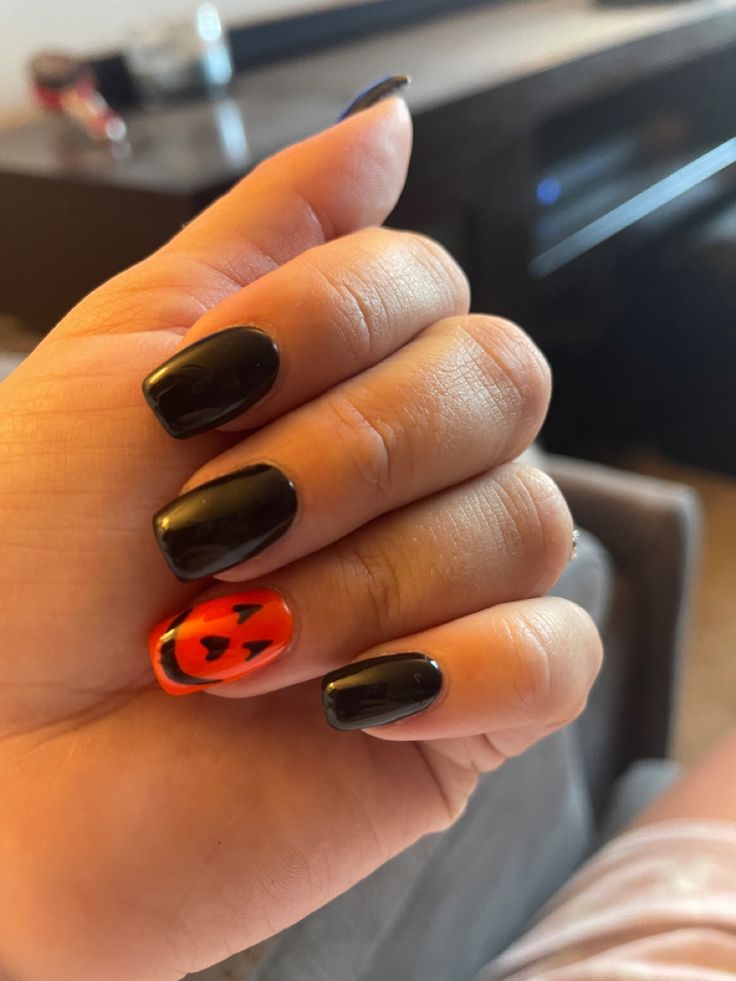 Festive Halloween Nail Design with Glossy Black and Vibrant Orange Accents