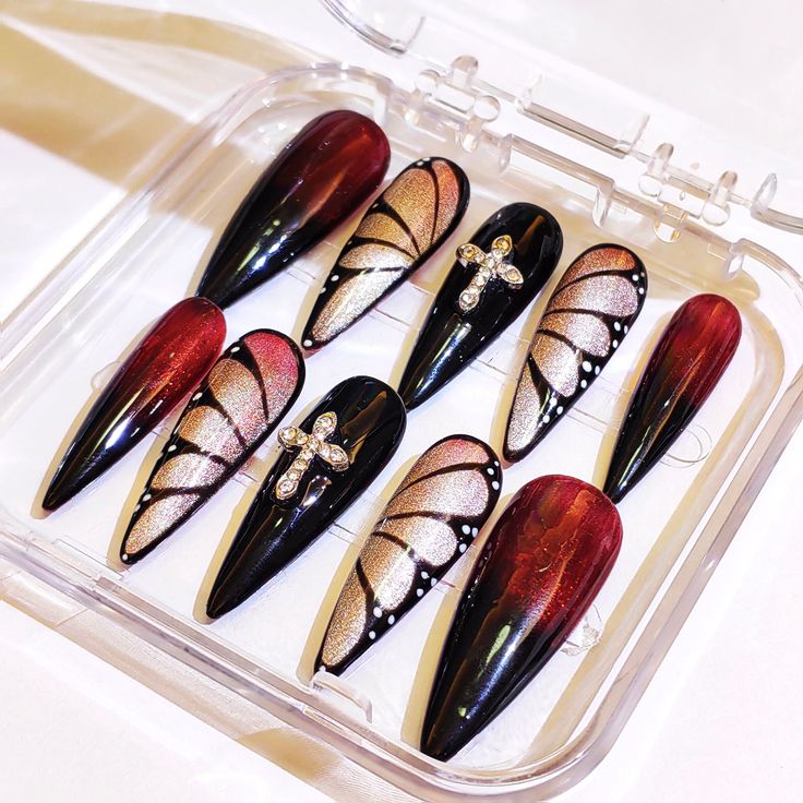 Elegant Stiletto Nail Design in Black and Deep Red with Intricate Gold and Silver Accents