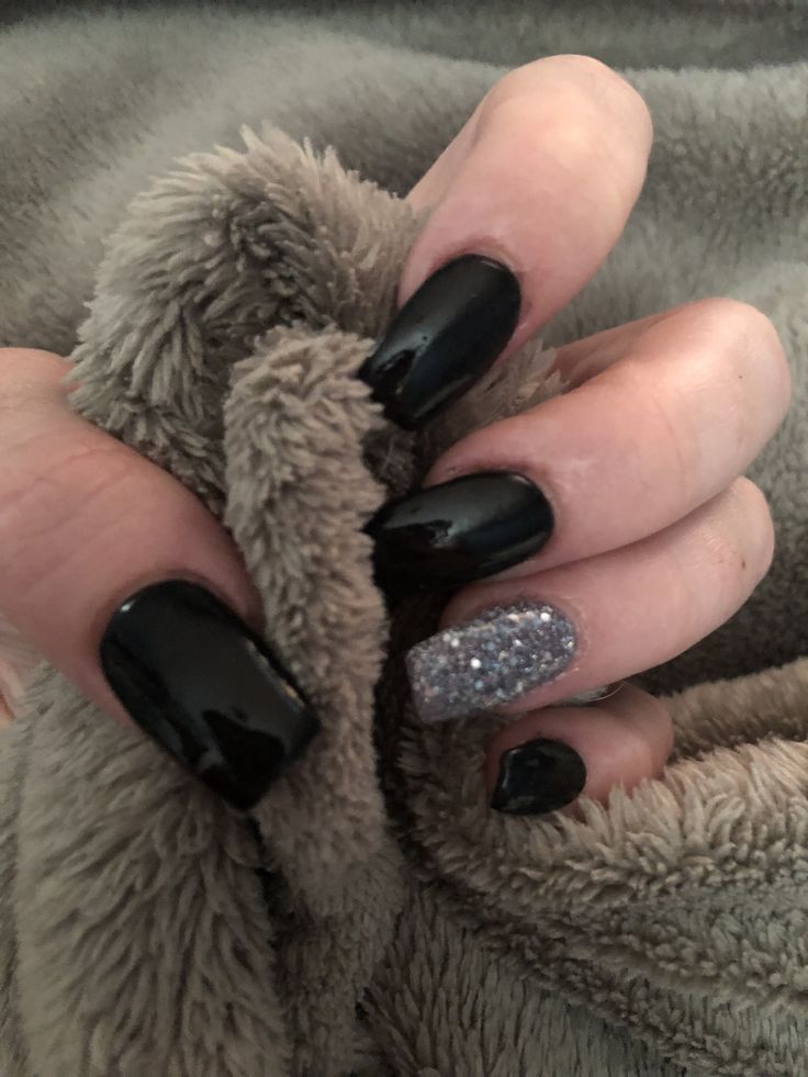 Chic Black Nail Design with Glossy and Sparkling Accents for Glamorous Occasions.