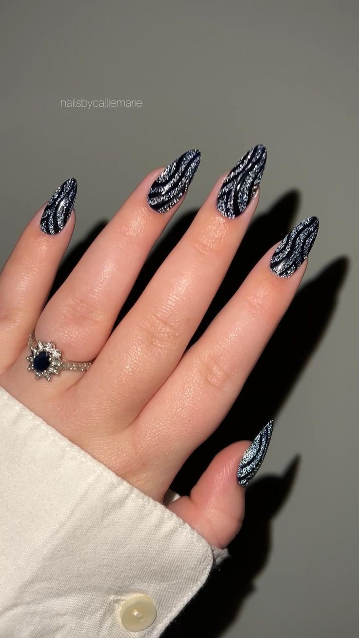 Elegant Almond-Shaped Nail Design with Striking Black and Silver Pattern.