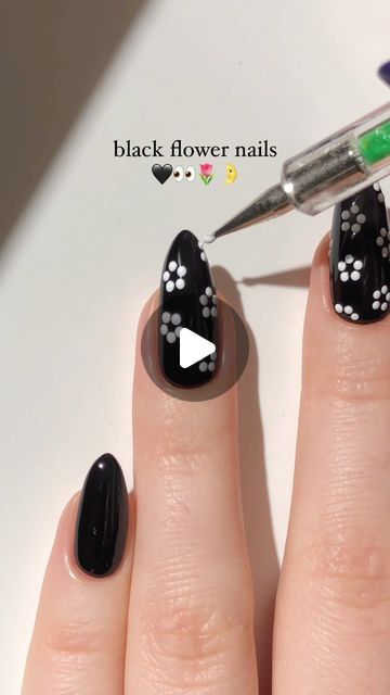 Sophisticated Black Flower Nails with Delicate White Floral Accents for a Striking Contrast.