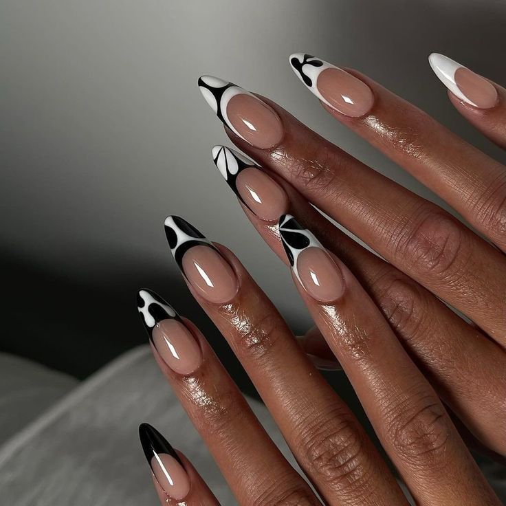 Chic Almond-Shaped Nail Design: Nude with Bold Black and White Accents.