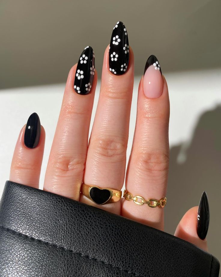 Chic Black and Nude Nail Design with Floral Accents for a Modern Feminine Look.