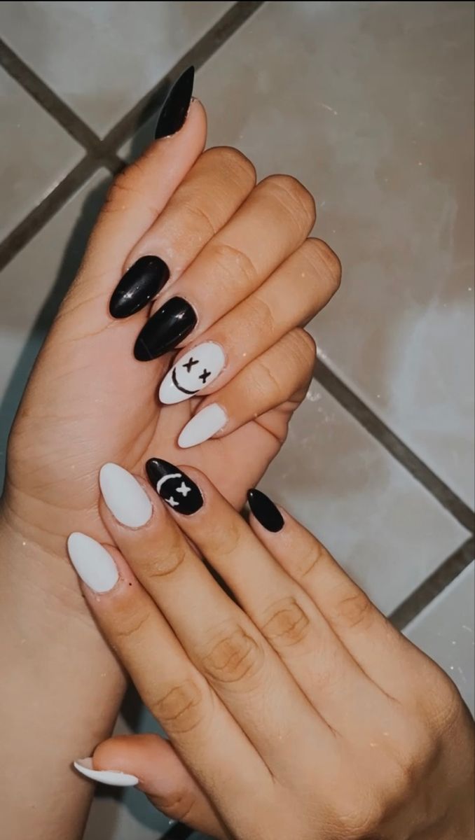 Chic Black and White Almond-Shaped Nail Design with Whimsical Patterns.