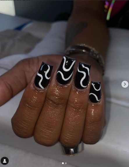 Bold Black and White Glossy Nail Design with Modern Abstract Patterns.