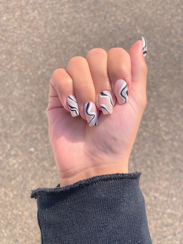 Elegant Marbled Nails: Soft Pink and Bold Black Lines in a Modern Design.