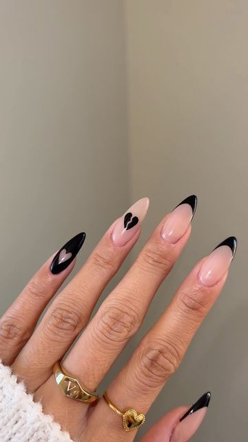 Chic Black and Nude Pointed Nail Design with Heart Accents.