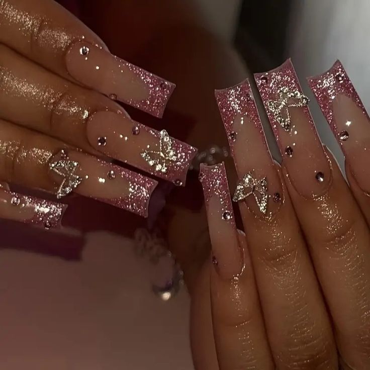 Elegant Ombre Nail Design: Nude to Shimmering Pink with Silver Stars and Rhinestones for Special Occasions.