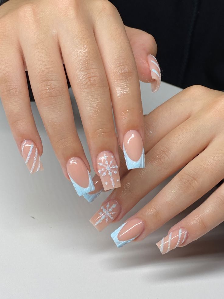 Chic Winter Nail Design: Soft Nude and Icy Blue with Snowflakes and Stripes