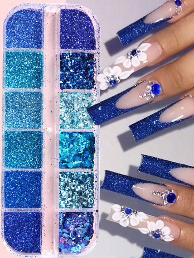 Elegant Blue Glitter Nail Design with Floral Embellishments and Gradient Shades.