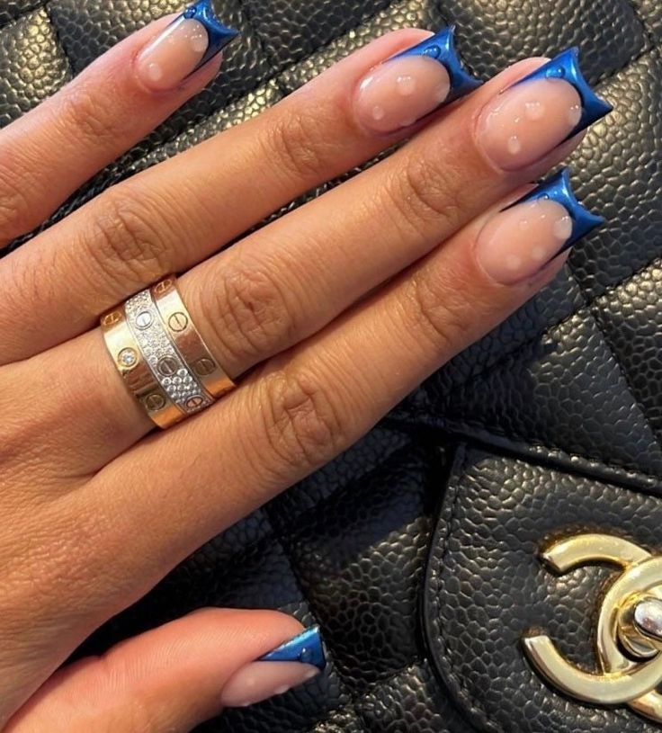 Modern Elegance: Striking Blue-Tipped Nails with Triangular Shape and Metallic Accessories