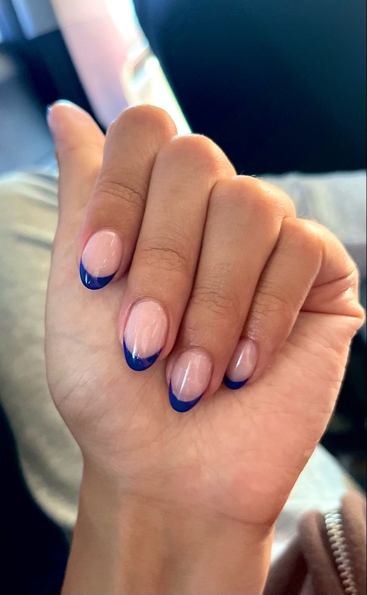 Chic Modern French Manicure with Bold Blue Tips on Soft Nude Base.