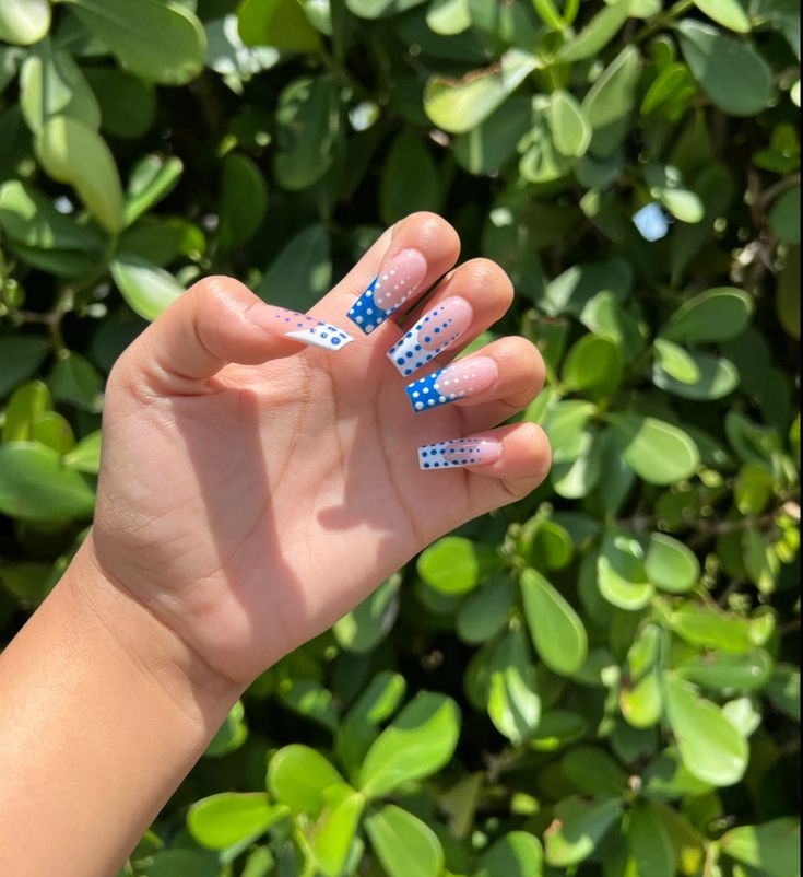 Vibrant Gradient Nail Design with Blue Tips and Playful Polka Dots for a Cheerful Summer Look.