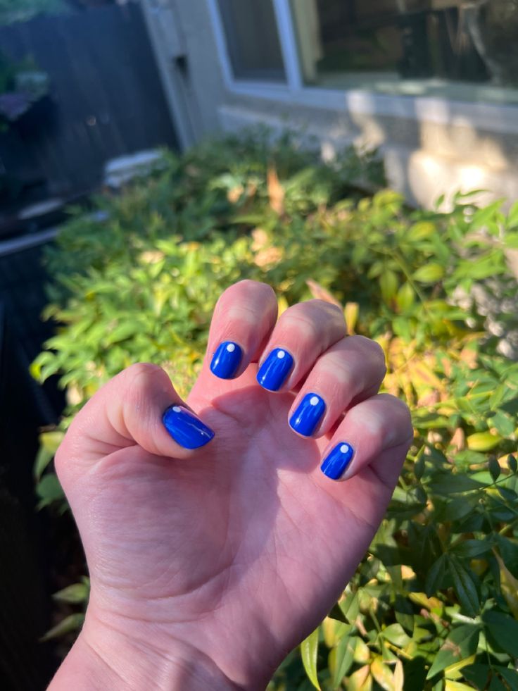 Playful Vibrant Blue Nails with Minimalist White Dots for a Fresh Modern Look.