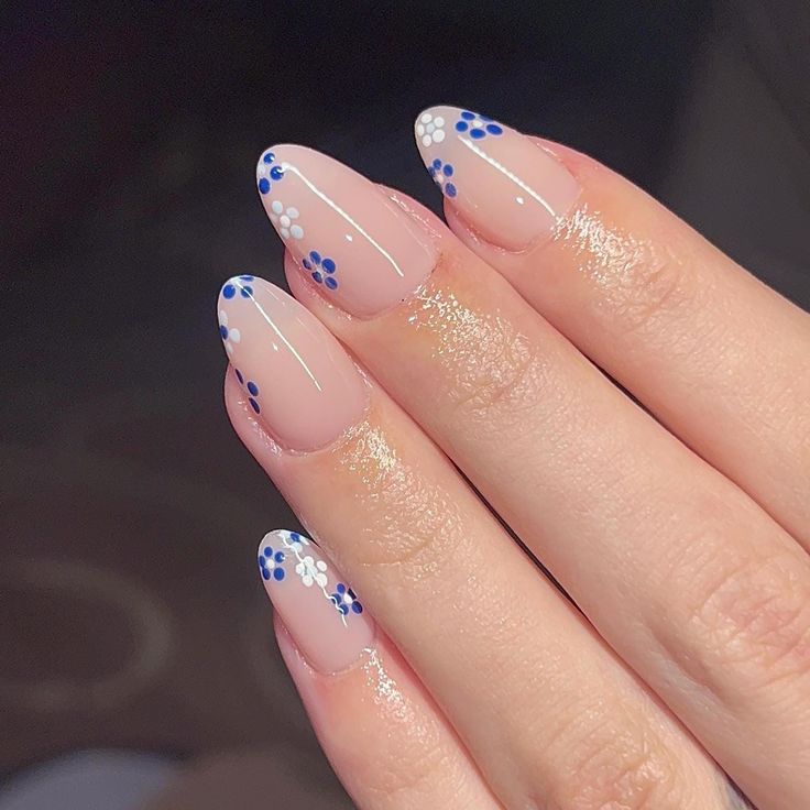 Elegant Floral Nail Design with Soft Nude Base and Delicate Blue & White Accents.