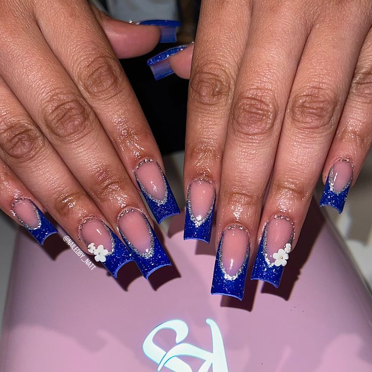 Elegant Blue Ombre Nail Design with Glitter and Floral Accents