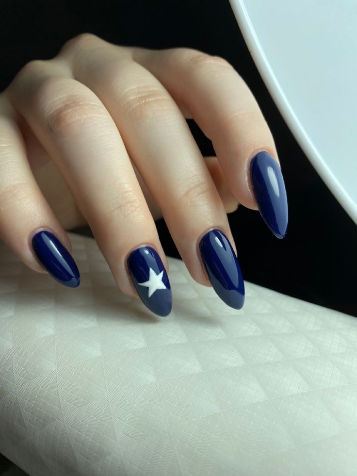 Elegant Navy Blue Nail Design with Glossy Finish and Playful Star Accent.