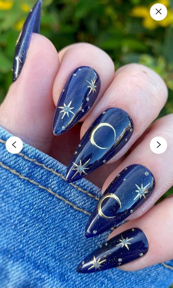 Celestial-Themed Navy Blue Stiletto Nail Design with Glittering Gold Accents.