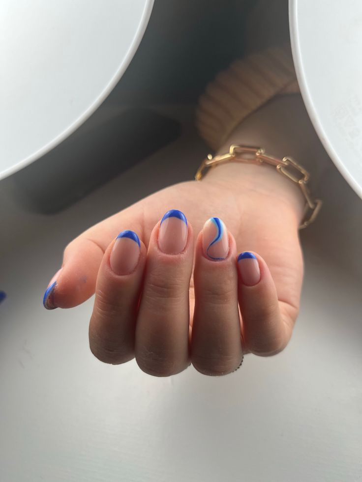 Playful Sophistication: Vibrant Blue-Tipped Nail Design with Nude Base and Artistic Waves