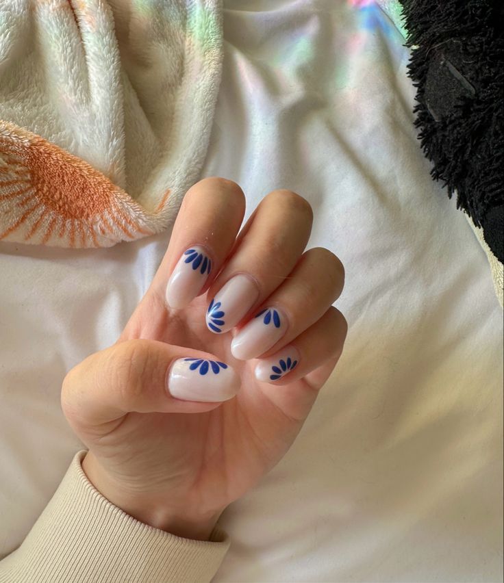 Elegant Soft White Manicure with Artistic Blue Floral Designs