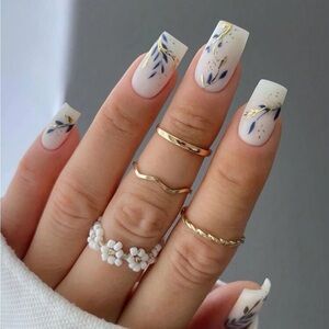 Elegant Floral Nail Design with Nude Base, Blue and Gold Accents, and Intricate Leaf Patterns.