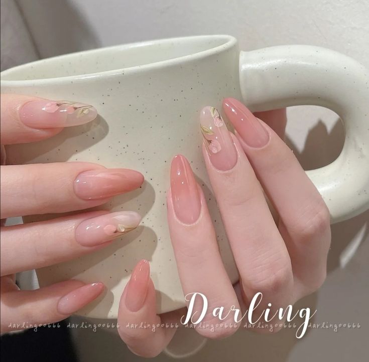 Sophisticated Soft Pink and Nude Nail Design with Floral Accents and Golden Touches.