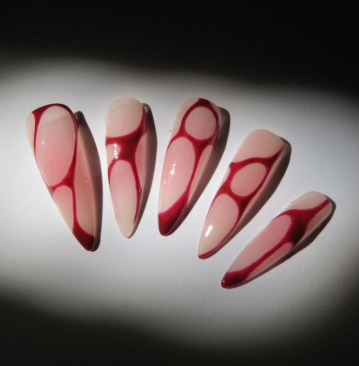 Bold yet Sophisticated Elegant Almond-Shaped Nails with Soft Pink Base and Deep Red Swirls.