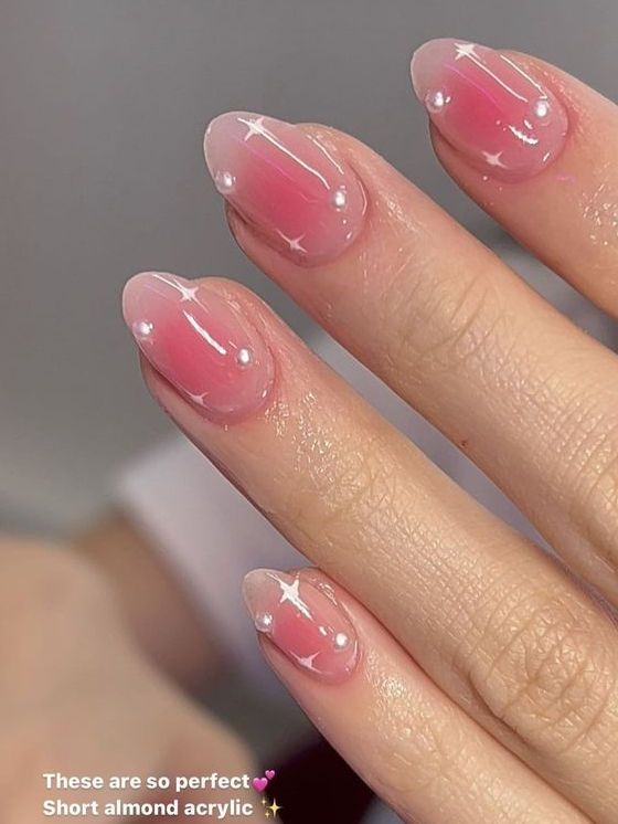 Delicate Almond-Shaped Acrylic Nails with Soft Pink Gradient and Elegant Embellishments.