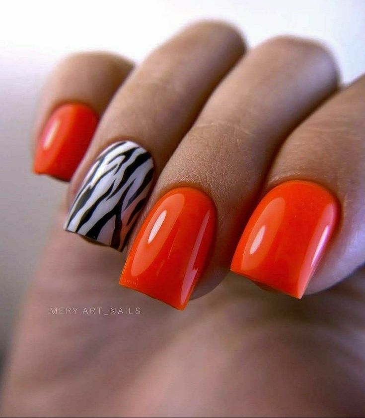 Bold Orange and Zebra-Striped Nails: A Fun Expression of Individuality.