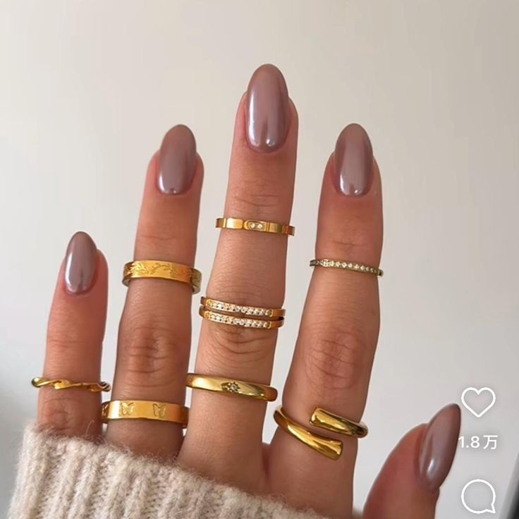 Elegant Almond-Shaped Nails in Glossy Taupe Paired with Delicate Gold Rings for a Timeless, Versatile Look.