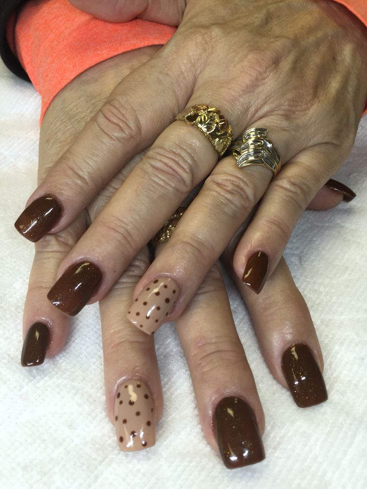 Sophisticated Elegant Brown Nail Design with Playful Polka Dot Accent.