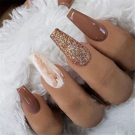 Sophisticated Nail Design: Glossy Brown Shades with Shimmering Glitter and Marble Accents.