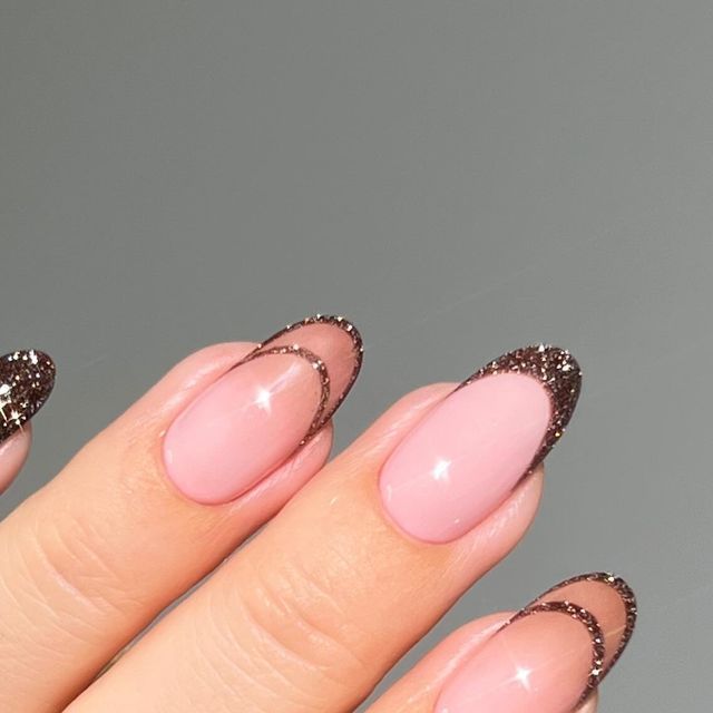 Chic Soft Pink Nail Design with Glossy Finish and Glamorous Dark Glitter Tips.