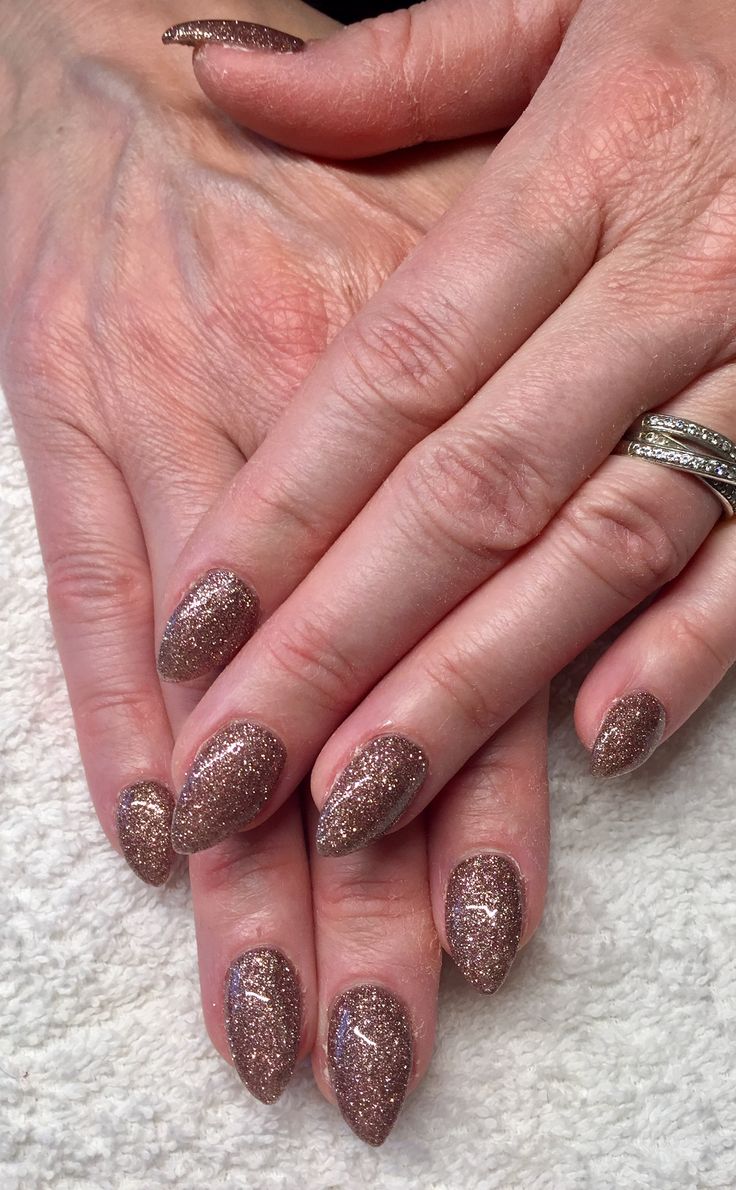 Elegant Rose Gold Glittered Almond Nails for Glamorous Occasions.