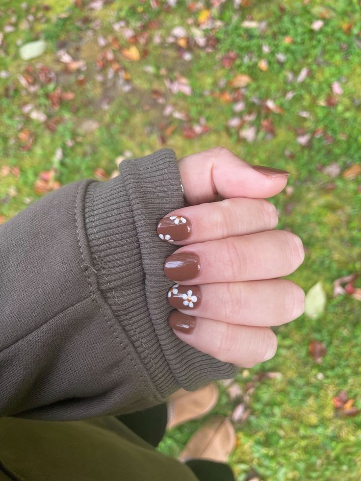 Charming Autumn-Inspired Nail Design with Rich Brown and White Floral Accents.