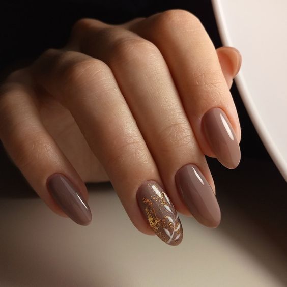 Sophisticated Almond-Shaped Nails with Warm Nude Base and Shimmering Gold Accent.