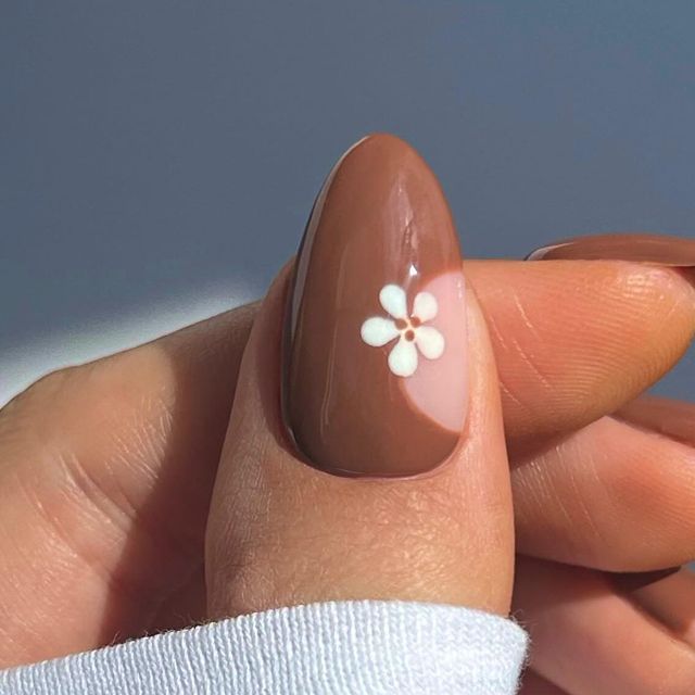 Sophisticated Minimalist Nail Design with Warm Brown Base and Delicate White Floral Accents.