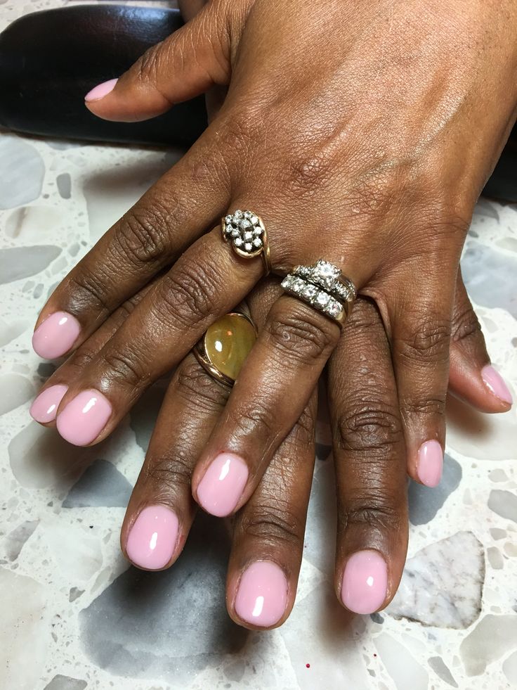 Elegant Pink Manicure Enhanced by Decorative Rings for a Polished Look.