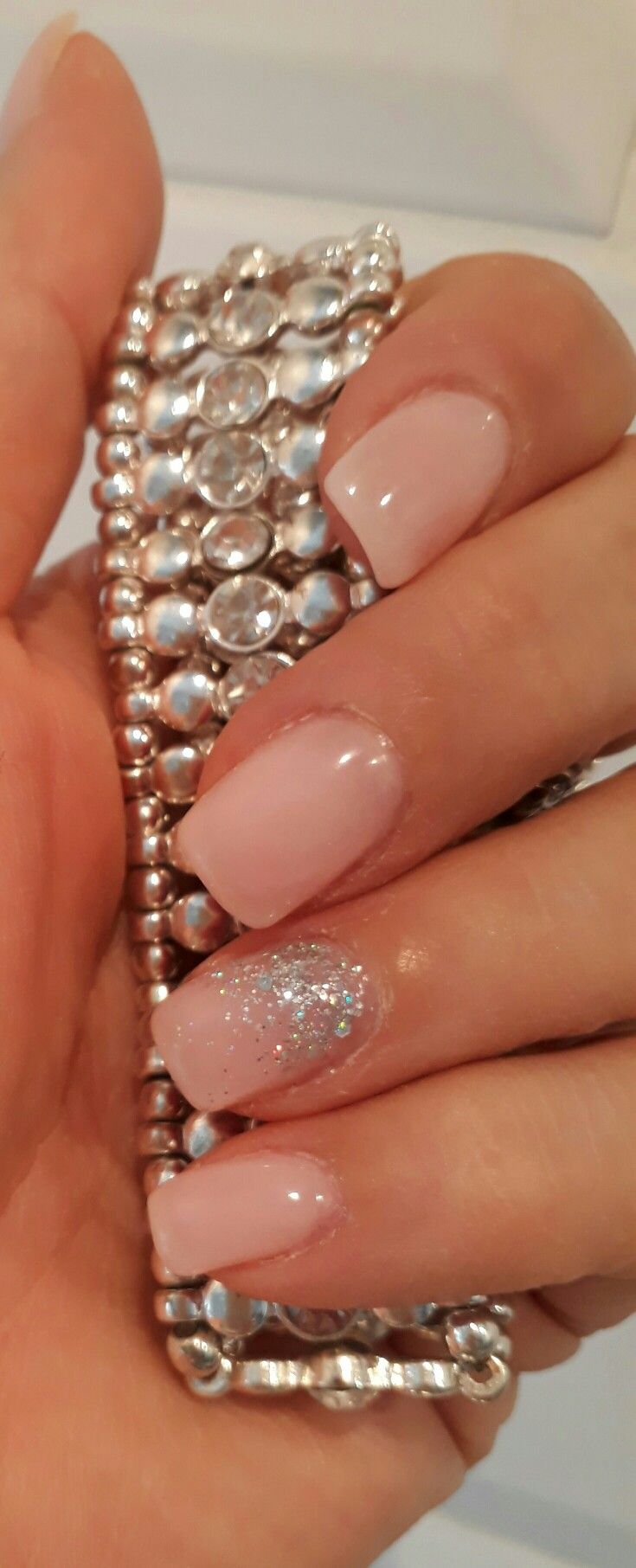 Elegant Soft Pastel Pink Nails with Sparkling Accent for Sophisticated Style.