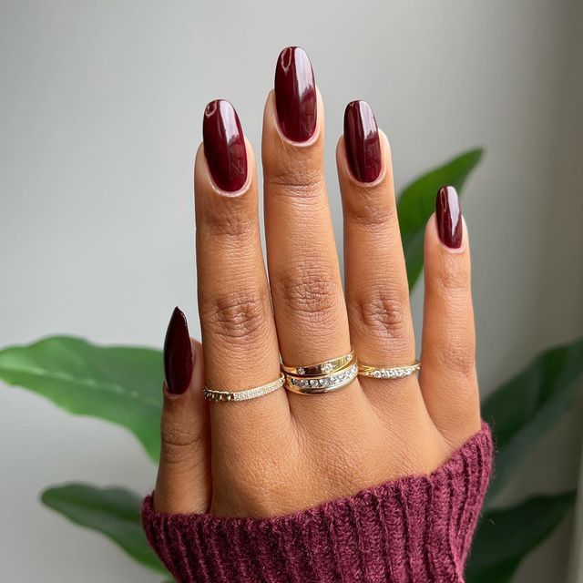 Elegant Glossy Burgundy Almond Nails: A Chic Seasonal Statement with Gold Accents.