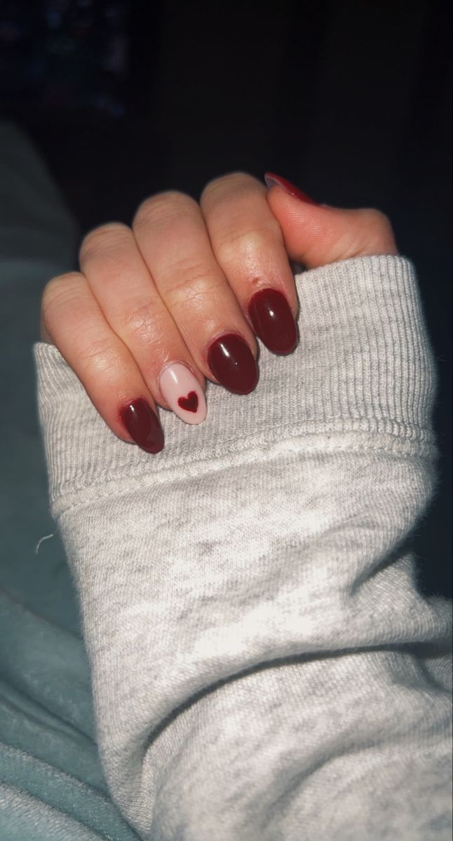 Elegant Nail Design: Deep Burgundy and Soft Pink with Heart Accent for a Playful Touch.