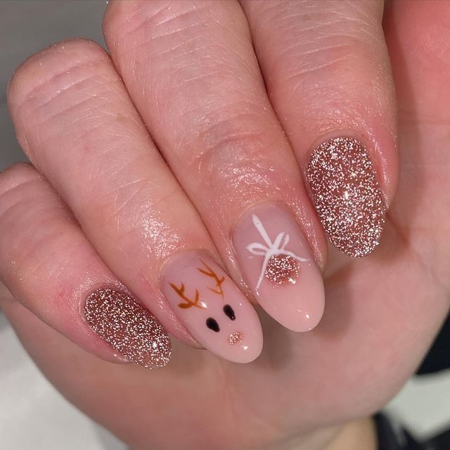 Playful Holiday Nail Design with Glittery Reindeer Motifs and Delicate Accents.